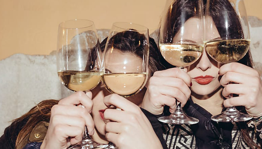 Two people holding up glasses of wine