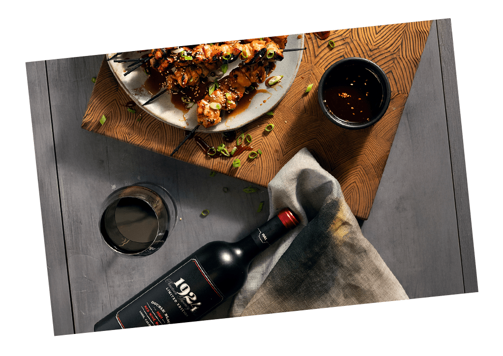 Cropped photo of a bottle of wine and food pairing plated on a cutting board