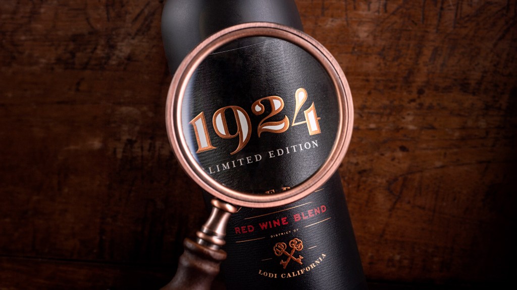 A magnifying glass focuses on the 1924 logo on the label of a bottle of 1924 Red Wine Blend